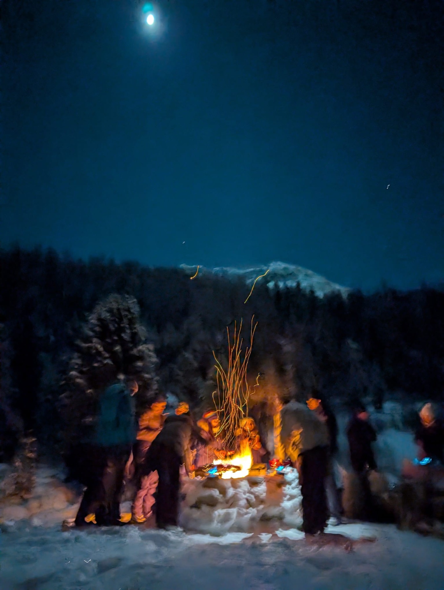 Campfire under a rising moon