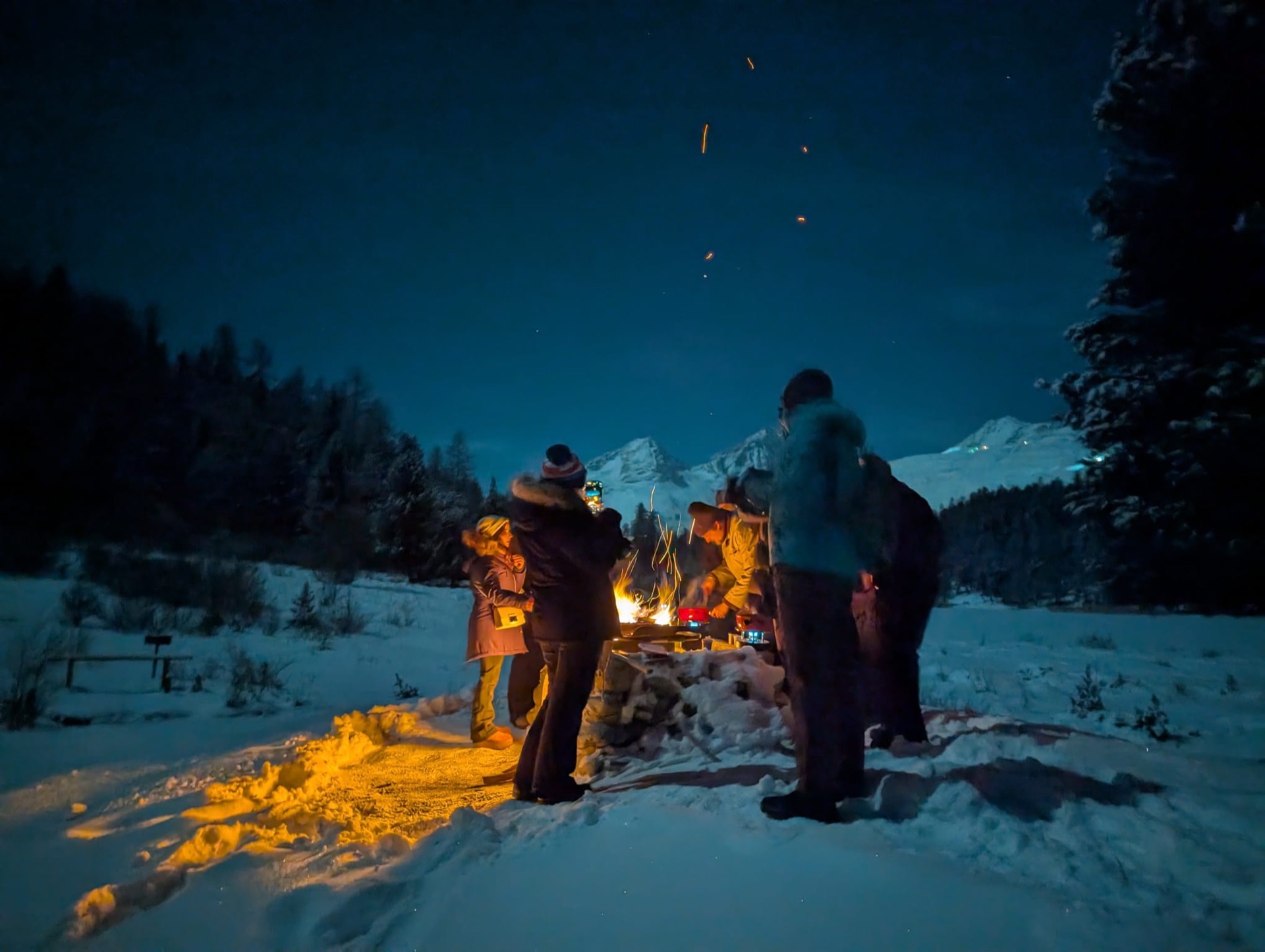 A group gathered around a winter campfire
