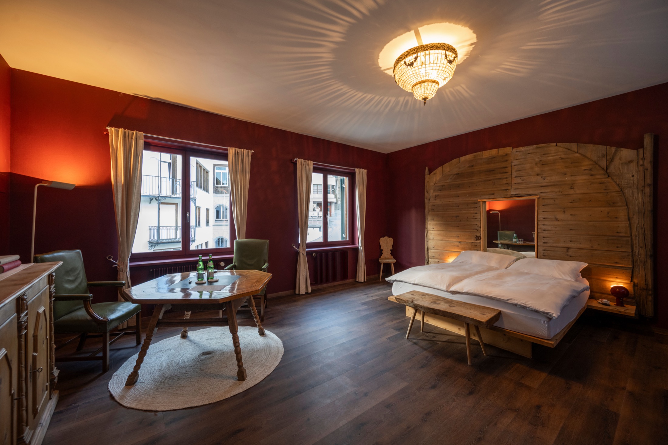 Junior Suite at Villa Beaulieu — arched reclaimed-wood headboard and town view
