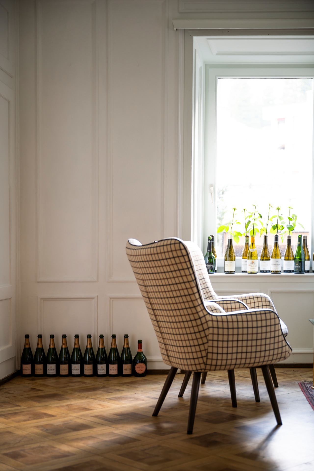 A wingback armchair with bottles of wine at Villa Beaulieu